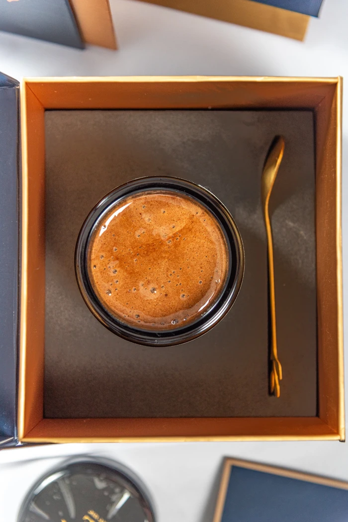 An open Immunis jar and gold spoon in its presentation box
